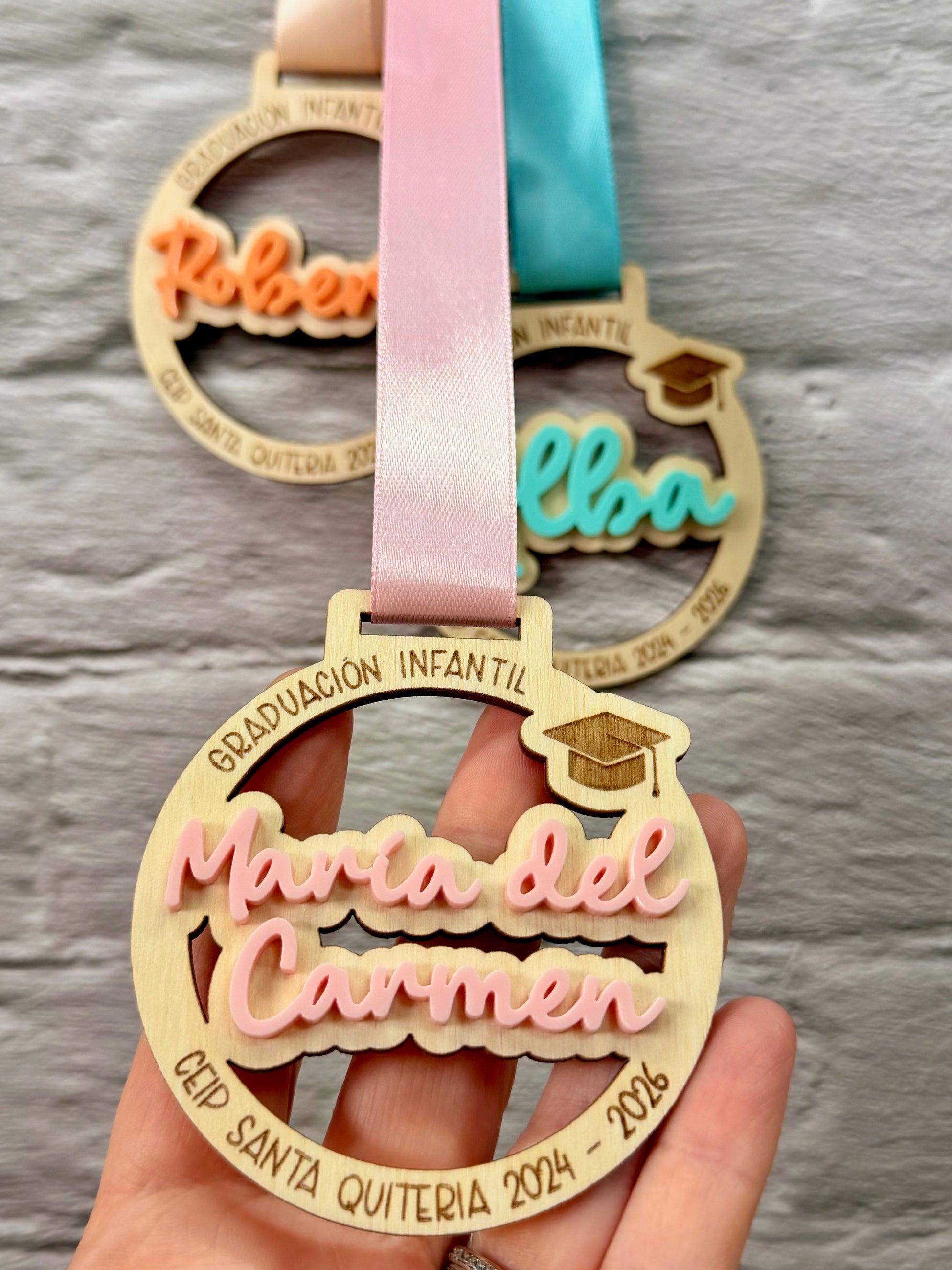Detalle medalla infantil grabada con nombre y centro