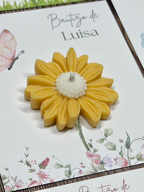 detalle de vela margarita sobre un carton de bautizo